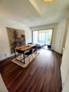 uma sala de jantar com uma mesa e cadeiras num quarto em Vacances cosy avec piscine 1 à 4 pers dans joli appartement em Sérignan