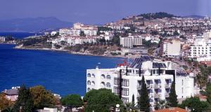 a large white building next to a body of water at Hotel Melike in Kuşadası