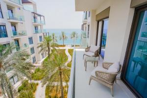 Un balcón con sillas y vistas al océano. en Nasma Luxury Stays - Fantastic Summer Getaway, Steps From The Beach, en Fujairah