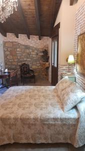 a bedroom with a large bed and a stone wall at La Posada del Canario in Cangas de Onís