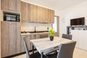 eine Küche mit einem Tisch und Stühlen sowie einem Kühlschrank in der Unterkunft Tenuta Croce Appartamento Karol-Piscina-Vista Mare in Salerno