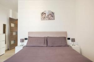 1 dormitorio con 1 cama con 2 cuadros en la pared en Tenuta Croce Appartamento Karol-Piscina-Vista Mare en Salerno