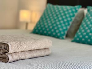 een stapel handdoeken bovenop een bed bij Spacious 1 Bed Apartment With Ocean View Balcony in Gibraltar