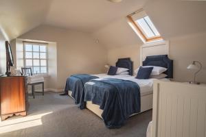 a bedroom with a bed with blue sheets and a window at John McDouall Stuart View in Dysart