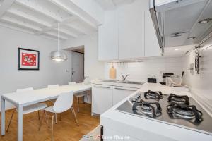 uma cozinha com armários brancos e um forno com placa de fogão em The Charme, TerreMarine em La Spezia