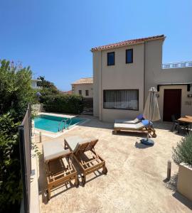 a backyard with a swimming pool and a house at Spilia Village Hotel & Villas in Spiliá