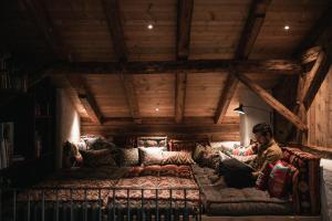 Ein Mann auf einer Couch in einem Zimmer in der Unterkunft Felder Alpin Lodge in Villanders