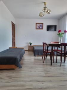 uma sala de estar com uma cama, uma mesa e cadeiras em Willa Anna Kluszkowce em Kluszkowce