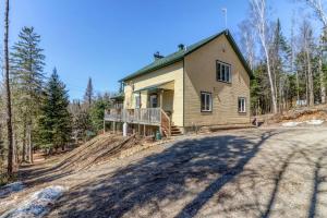 a house on the side of a dirt road at Chalet aux mille étoiles near Mt-Tremblant with Hot Tub in La Conception