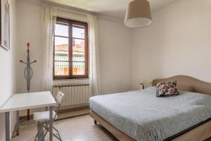 a bedroom with a bed and a desk and a window at Apartments Volpino - Affitti Brevi Italia in Lucca