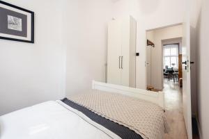 a white bedroom with a bed and a dining room at Apartamenty Woźna 14a, 2 rooms, self check in 24h in Poznań