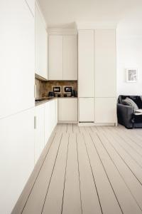 een witte keuken met witte kasten en een bank bij Apartamenty Woźna 14a, 2 rooms, self check in 24h in Poznań