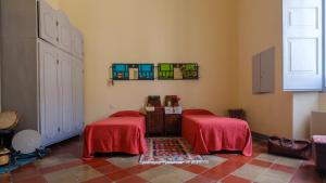 een kamer met 2 bedden met rode lakens en een raam bij Italianway - Dammuso San Cesario in San Cesario di Lecce
