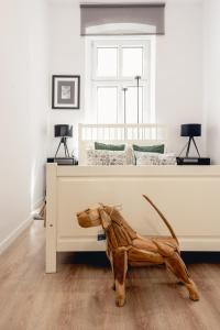 Apartamenty Woźna 14a, 2 rooms, self check in 24h في بوزنان: تمثال خيل خشبي يقف بجانب السرير