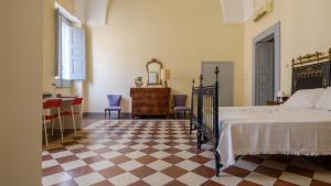 een slaapkamer met een bed en een geruite vloer bij Italianway - Dammuso San Cesario in San Cesario di Lecce