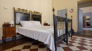 een slaapkamer met een groot zwart bed met witte lakens bij Italianway - Dammuso San Cesario in San Cesario di Lecce