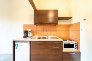 a kitchen with a sink and a microwave at Angel's Studio 4 in Agios Georgios Pagon +21 photos