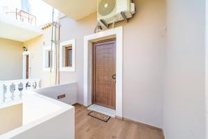 a hallway with a brown door in a house at Angel's Studio 4 in Agios Georgios Pagon