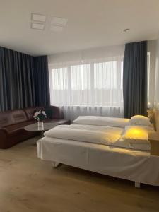タウラゲにあるViešbutis Bangaのベッドルーム(大型ベッド1台、ソファ付)