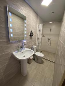 a bathroom with a sink and a toilet and a mirror at Viešbutis Banga in Tauragė