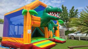 a large inflatable dinosaur house in the grass at Camping Les Alizés in Saint-Hilaire-de-Riez