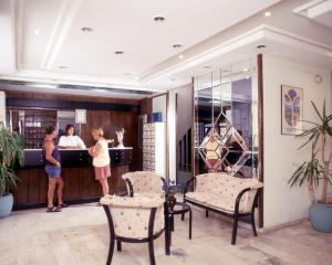 two people standing at a counter in a hotel lobby at Hotel Melike in Kuşadası +61 photos