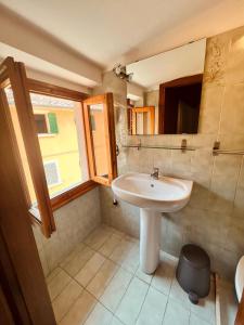 baño con lavabo blanco y ventana en Albergo Dal Fata, en Gambassi Terme