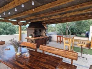 a patio with a table and an outdoor oven at Apartments Jelinic in Polača