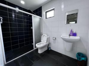 a bathroom with a toilet and a sink and a shower at Naam Boutique Lodge in Port Dickson