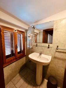 ein Bad mit einem Waschbecken und einem Spiegel in der Unterkunft Albergo Dal Fata in Gambassi Terme