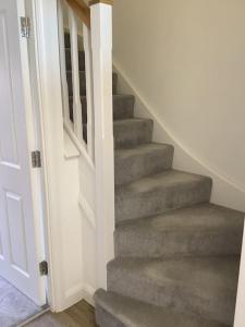- un escalier dans une maison dotée d'un tapis gris dans l'établissement Entire 2 bedroom house in Tamworth, à Tamworth