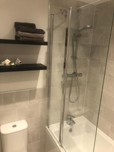 a shower with a glass door next to a toilet at Entire 2 bedroom house in Tamworth in Tamworth
