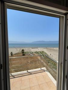 een glazen schuifdeur met uitzicht op het strand bij Relax Rental in Vlorë