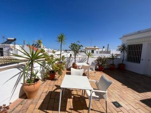 a patio with tables and chairs on a roof at Hostel Conil in Conil de la Frontera