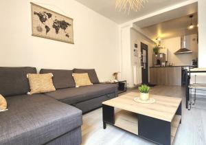 a living room with a couch and a table at "Cozy Zen" 1 grande chambre - Calme - Arrivée autonome - 6 pers - Parking gratuit in Tours
