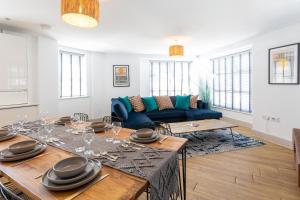 uma sala de estar com uma mesa e um sofá azul em Oxford Heights em Southampton