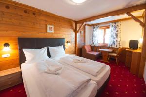 a bedroom with a large white bed in a room at Tirolerhof - inklusive Super Sommer Card in Serfaus +18 photos