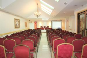 una sala de conferencias con sillas rojas y una pantalla en Hotel Guerrero en Mar del Plata