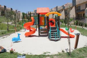 ein Spielplatz mit Rutsche in einem Park in der Unterkunft Al Wadi Touristic Resort in Al Shafa
