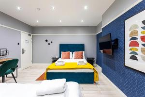 a bedroom with a blue and yellow bed and a couch at Philbeach Gardens Rooms in London
