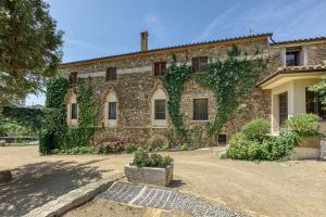 a large stone building with ivy growing on it at Mas Cusi in Palau-Saverdera