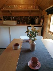 a kitchen with a table with a vase of flowers on it at Le kota des 3 tilleuls in Dampierre-sur-Salon