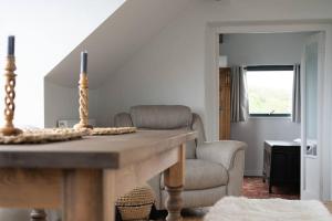 a living room with a table and a chair at Cliff-top Cottage on Coast Path w/Panoramic Views in Trevine