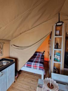a tent with a bed and a sink in a room at Tendu' Punta Bianca Glamping Camp in Palma di Montechiaro