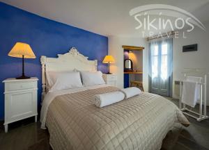 a bedroom with a bed and a blue wall at Traditional Maisonette with picturesque Chora View in Chora Folegandros
