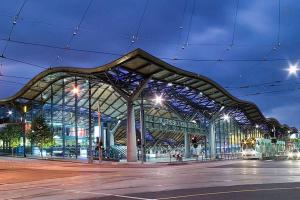 een groot gebouw met een glazen gevel 's nachts bij A Cozy & Lux Apt Next to Southern Cross Station in Melbourne
