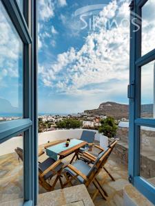uma vista a partir da varanda de uma casa com uma mesa e cadeiras em Traditional Maisonette with picturesque Chora View em Chora Folegandros