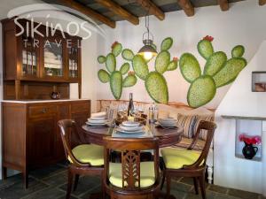 une salle à manger avec une table et des chaises ainsi qu'une fresque murale de cactus dans l'établissement Traditional Maisonette with picturesque Chora View, à Folégandros