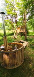a wooden tub with a fountain in a yard with a house at Treehouse LEA in Mikulášovice
