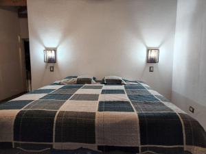 1 dormitorio con 1 cama con 2 almohadas en Chalet Santa Teresita, en Amatitlán